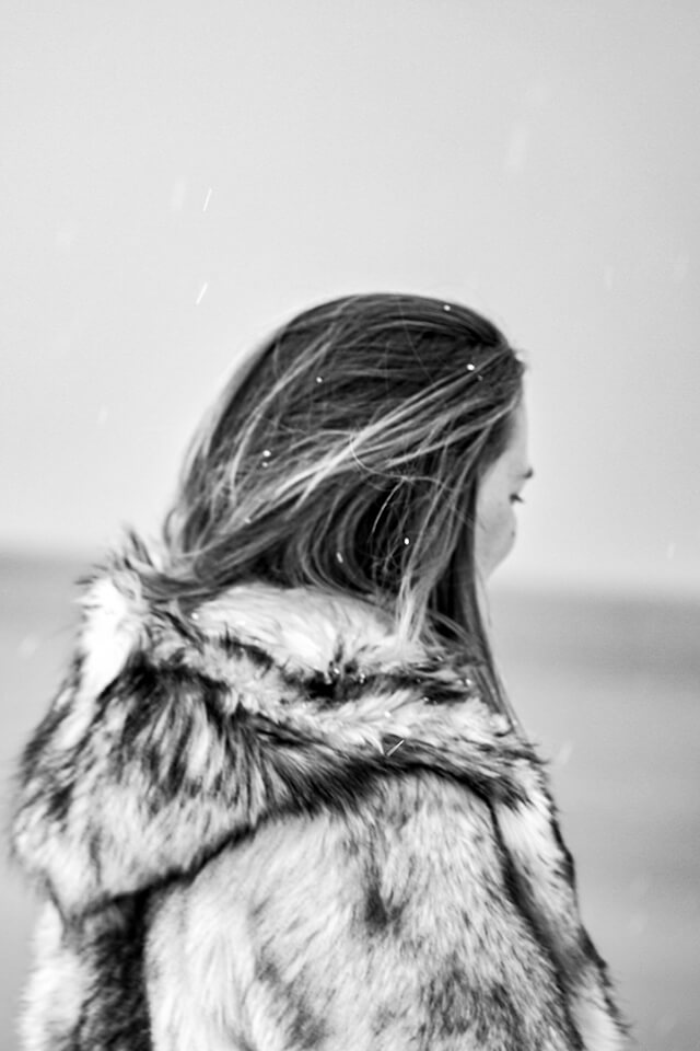 Fotografie zeigt Jessica von schräg rechts hinten in einen Mantel gehüllt, umgeben von Schnee und Eis